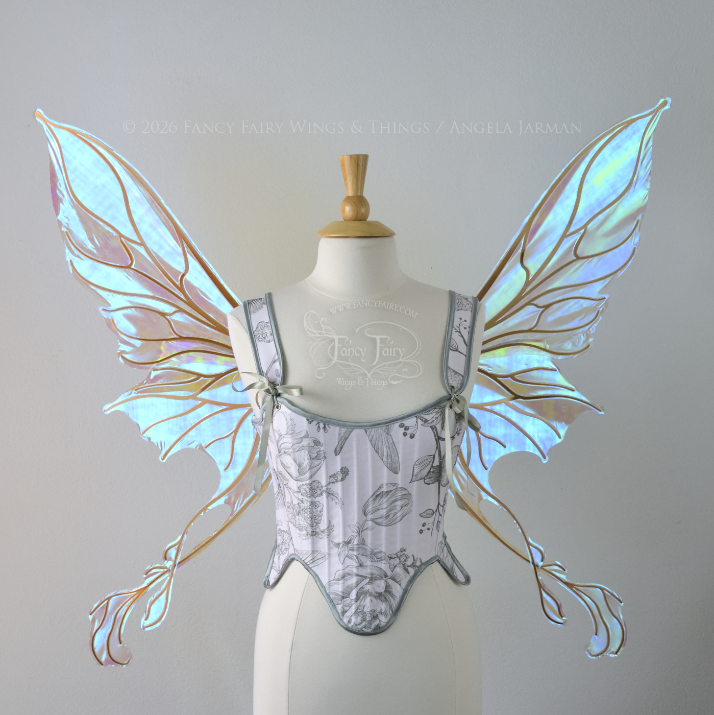 Transparent blue / green iridescent fairy wings with pointed upper tips and 2 swirling tails on the bottom panels with copper veins, worn on a dress form, front view
