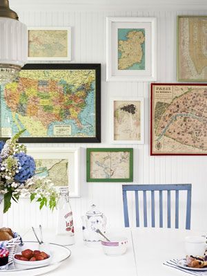This dining area displays a really interesting and eclectic display of different maps in varying frames and colours. They work well against the white background and with the coloured chair.