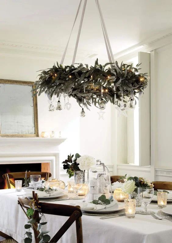 Adding greenery to your ceiling lights or up high is relatively simple to do, but will instantly provide a focal point and give a much greater impact. Finish off with some sprigs for the table and place settings. So easy and so effective! Candles will provide a twinkling flicker as the night draws in. Source: godfather style.com