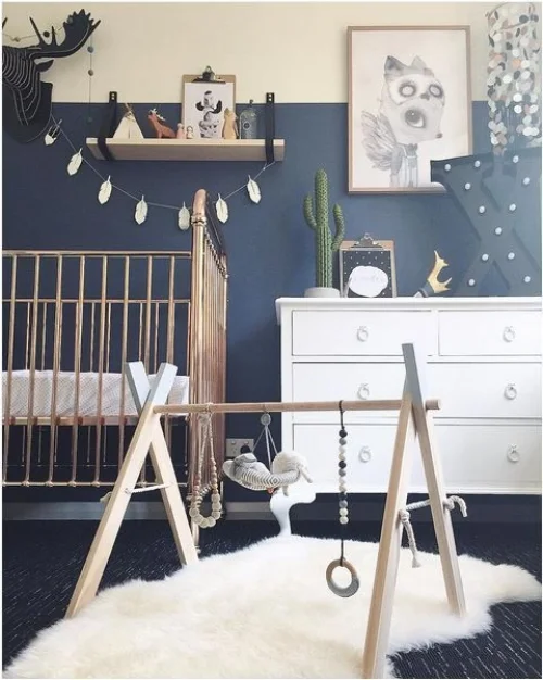 The blue wall colour here is a bold choice, particularly as the floor is dark, but together they look beautiful. This is because the cream colour wall two thirds up helps to soften it. They've cleverly used pictures, wall and ceiling hangings and shelving to bridge the two colours together. The white drawers, rug and wooden cot lighten and brighten the overall scheme. A relaxing and cosy room. Photo: southernhaus.com
