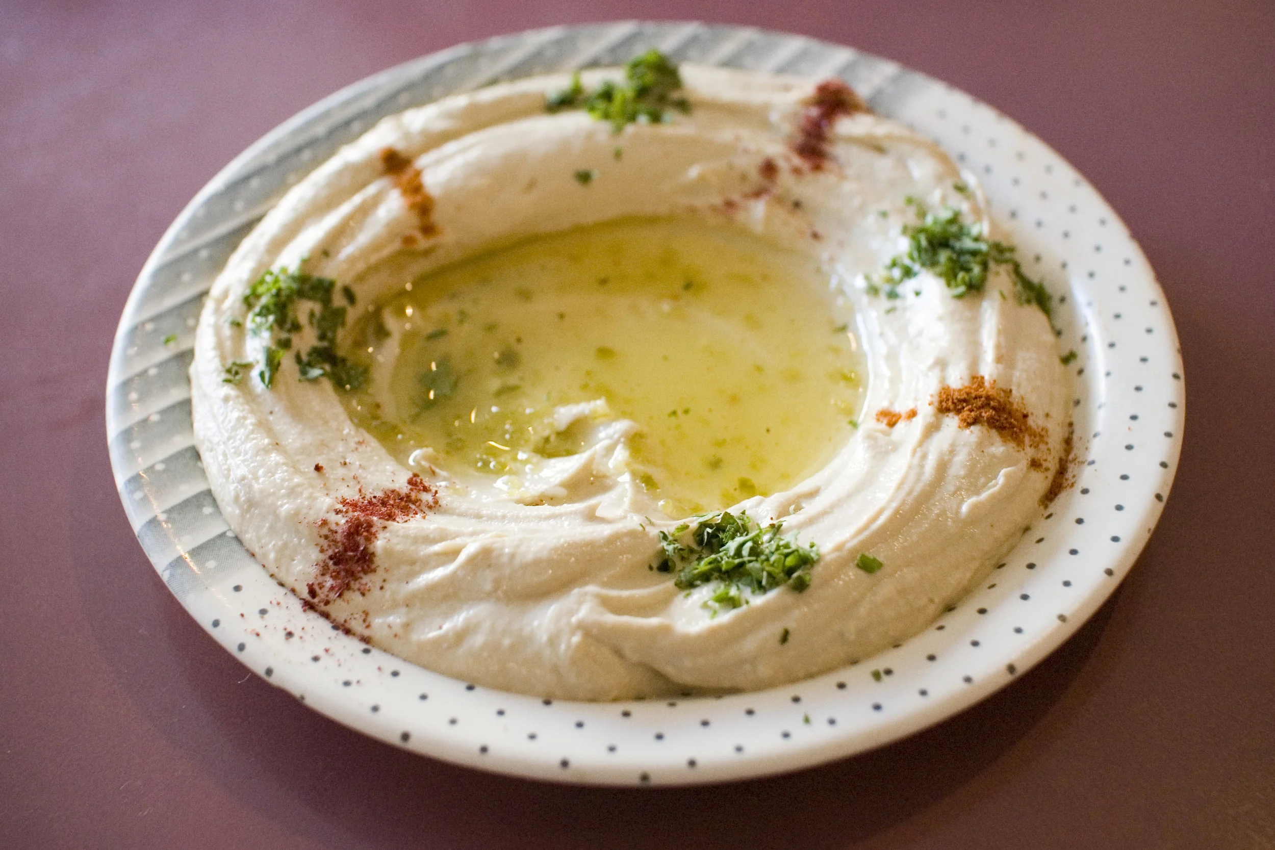 A plate of hummus as it would be presented to you at a traditional Middle Eastern restaurant