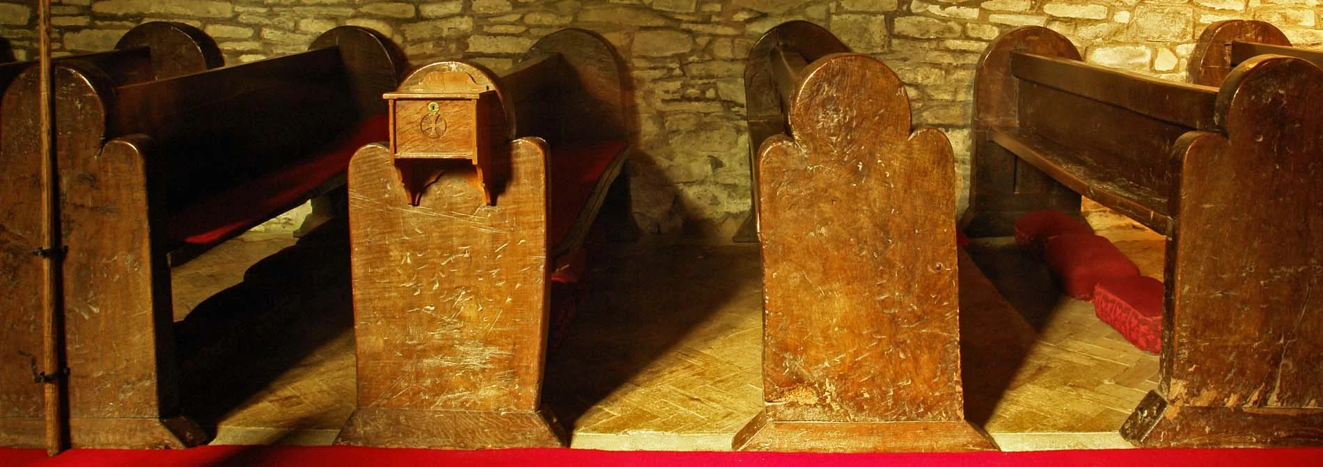 Roughly carved trefoil ended pews on the north side of the nave