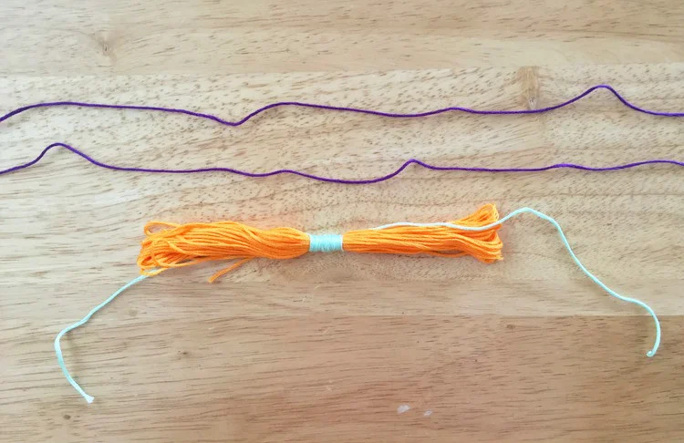 3. Ahora el hilo del próximo color córtalo en dos y amarra uno de ellos al lado izquierdo (cinco vueltas) y el otro a la derecha (cinco vueltas). // Now cut the thread of the next color in half and circle around the left (five times) and the other to the right (five times).