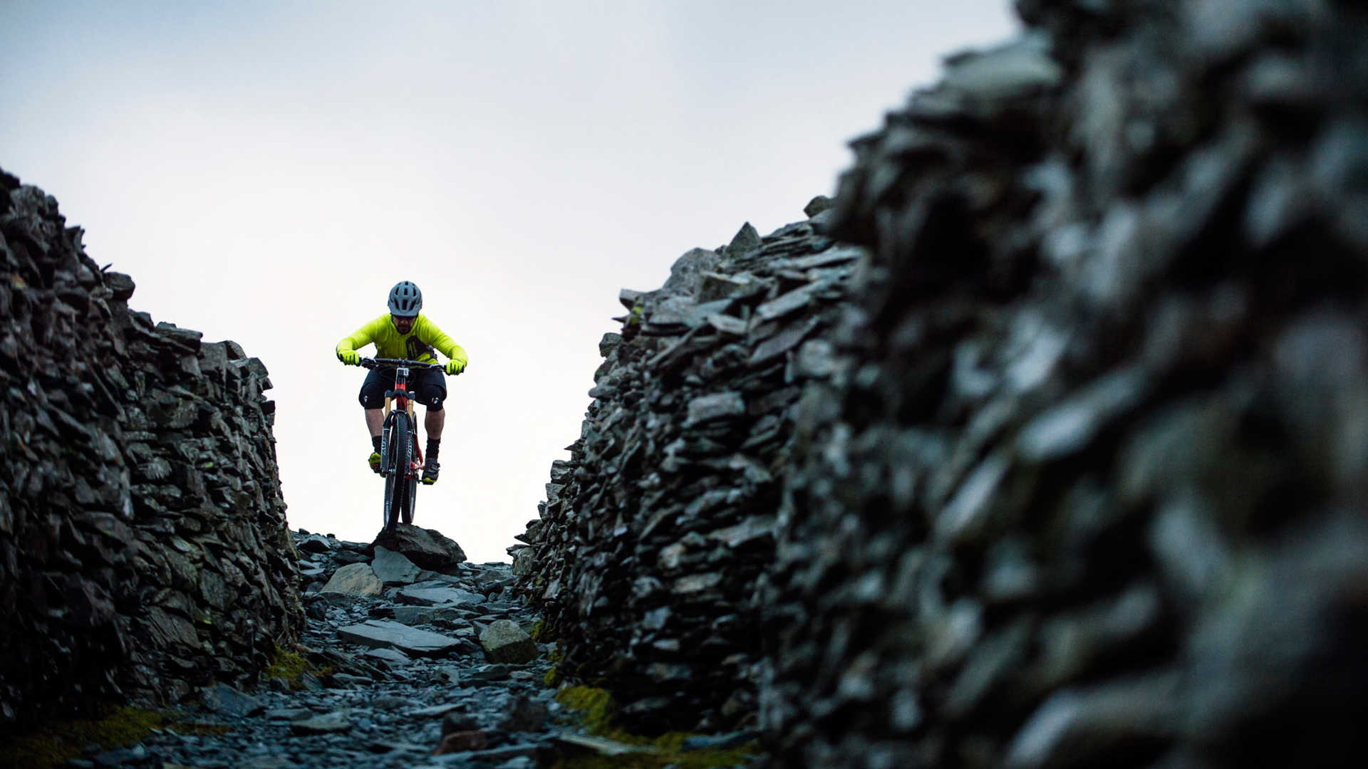 The term “trail” has a loose interpretation in England. Not too unlike the early days of mountain biking when trails weren’t built specifically for the flow and rhythm of a two-wheeled fun machine, the trails we found near Kentmere, England were truly multi-use. Hikers, horses, cattle and sheep all follow a similar traverse across the wind-weathered land, ascending peaks in the shortest line-sight way rather than a thoroughly thought-through energy-saving method. We traveled to this island to test our new apparel in the land for which it was designed — snow, rain, mud, cold. And when we arrived, we found it in spades. Our photographer became our guide, taking us to a diverse set of trails. From the newly formed Ride Center, to the shale mines, and over to the tourist-haven Keswick, we tested the limits of layering, crossed the lines from waterproof to mudproof, and determined that former stewards of the land knew exactly where we’d become too tired and cold to continue, providing huts and shelter at the most strategic way points. As we completed our journey and drove back to London, we deemed the trip a success. Clothing caked in mud, bikes thoroughly worked, and grins from ear to ear, relishing in the warm delight of yet another piece of baked bread.