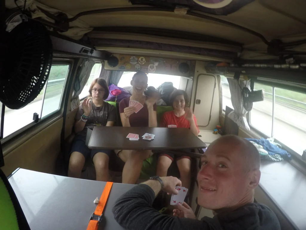 Imke and David engaged in a game of cards with J and Coconut while hitching a ride.