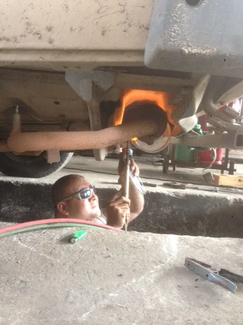 The mechanic, too cool in his shades, tires to set Wesley on fire