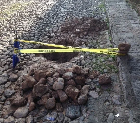 Unfortunately, Mexico public works are not as efficient as the DMV. We called the local water company about a leaky pipe in the street outside our house. It took two days before a group of four guys with shovels and pick axes showed up and dug this hole in the street. They repaired the leak with tape and wire. After securing the site with an official ‘waterworks’ umbrella and some ‘caution’ tape, the group went to get lunch. They came back a few hours later and threw dirt in the hole but left a pile of rocks on our sidewalk. When the late afternoon rains came, much of the dirt washed away leaving a nice crater.