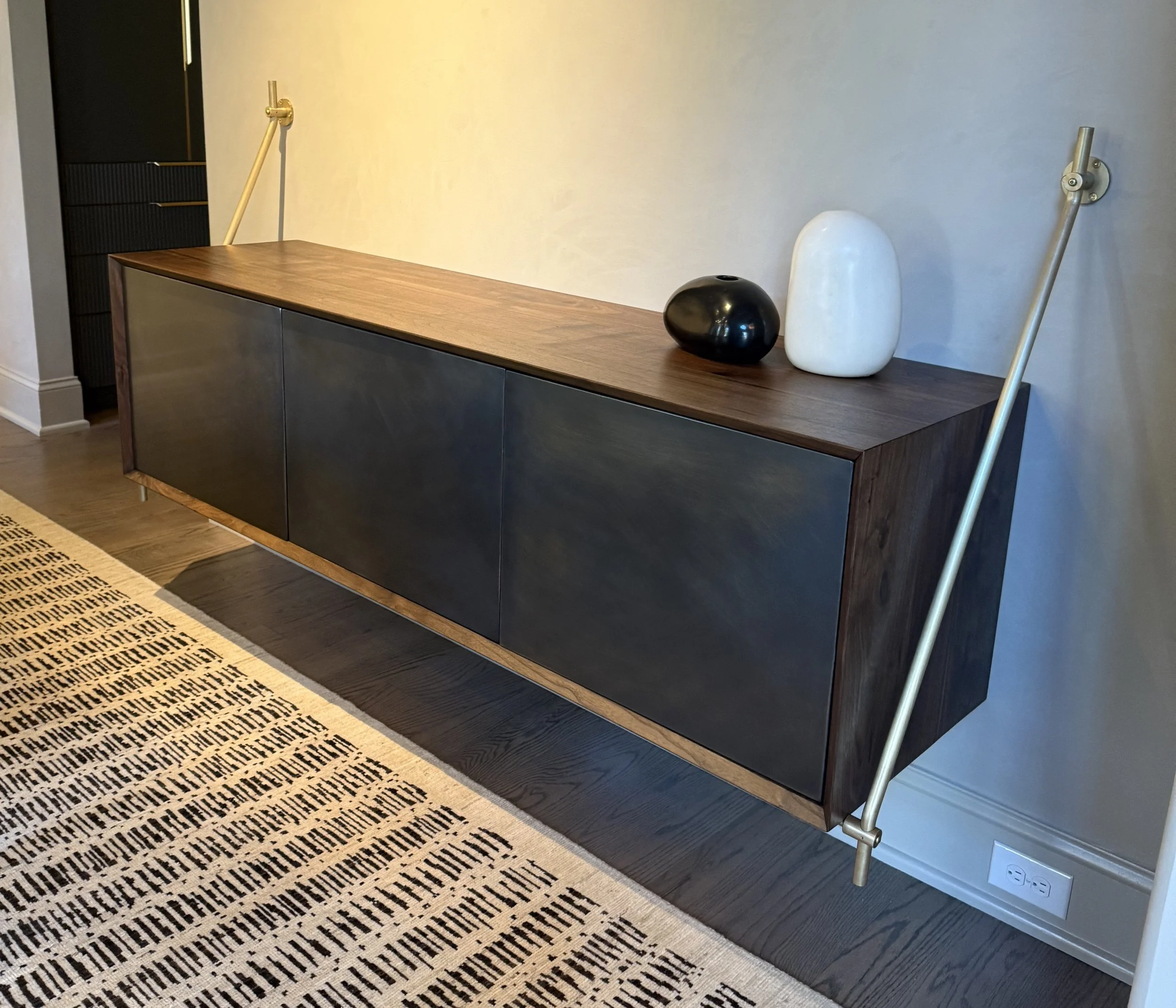 Walnut hanging cabinet with blackened brass wrapped doors