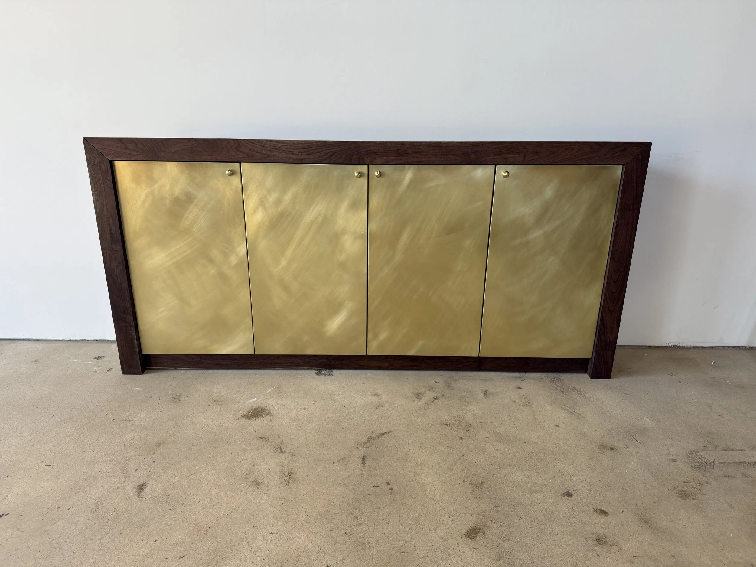 Walnut cabinet with burnished brass wrapped doors