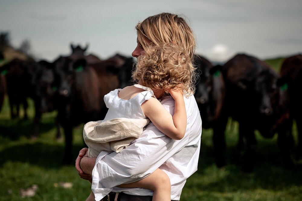 young girl hugs mum on their farming property