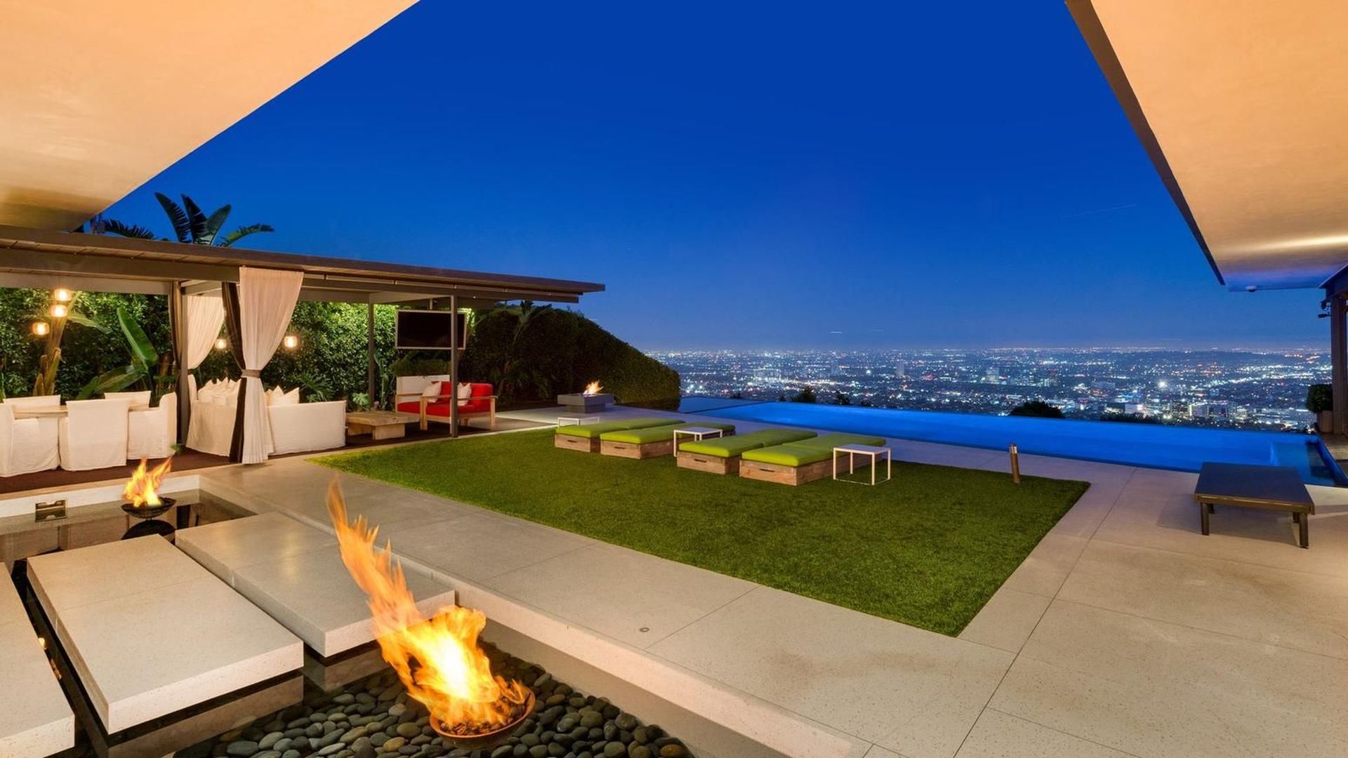 The infinity pool is lit with led lighting and cascades down overlooking the city, with views that expand from Hollywood Hills over Downtown LA to the Pacific Ocean.