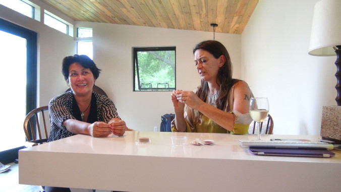 Hope and Micol record a video interview while peeling nipple stickers before the community dinner.