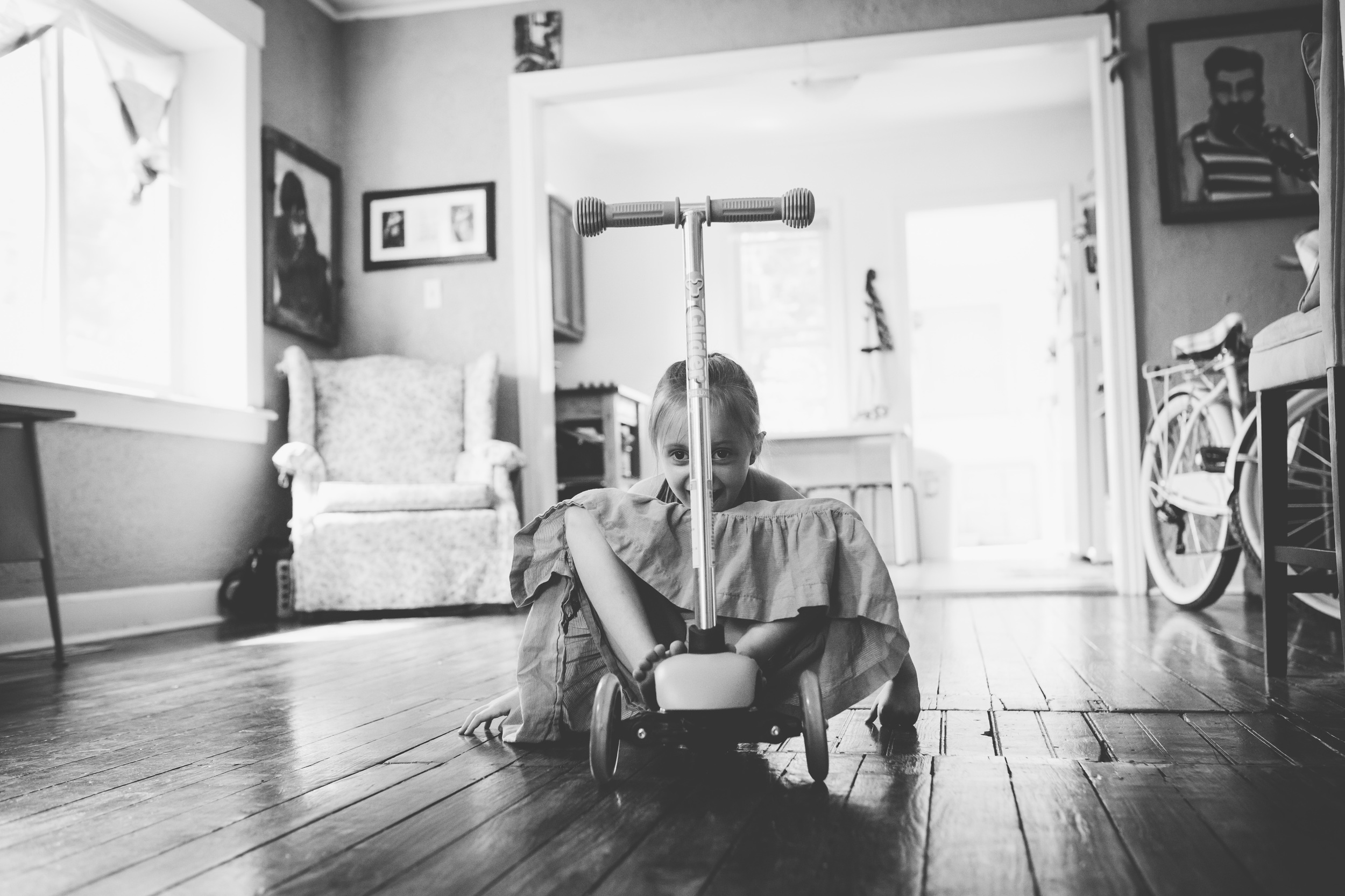 Little girl sitting on scooter.