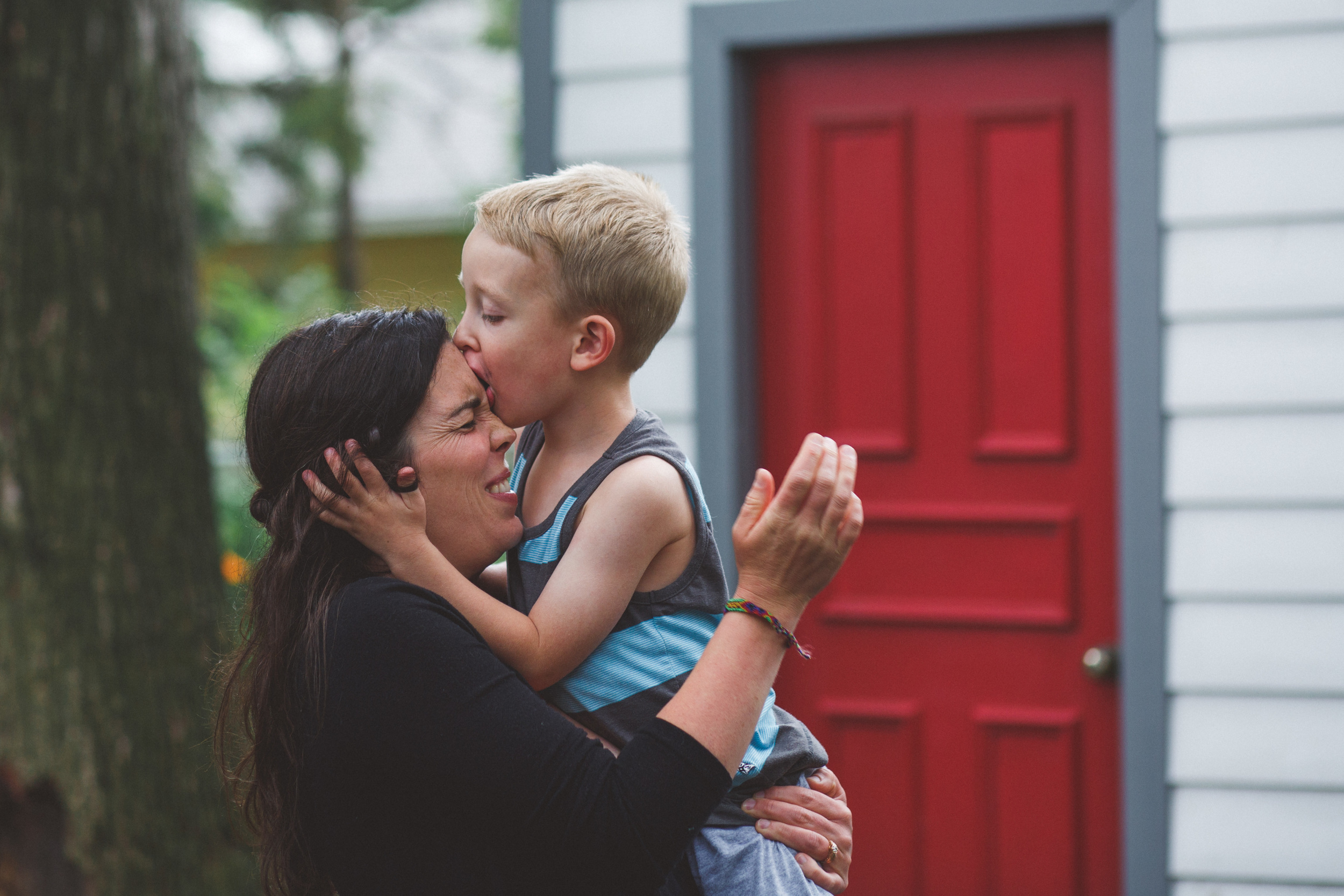 Son biting moms forehead.