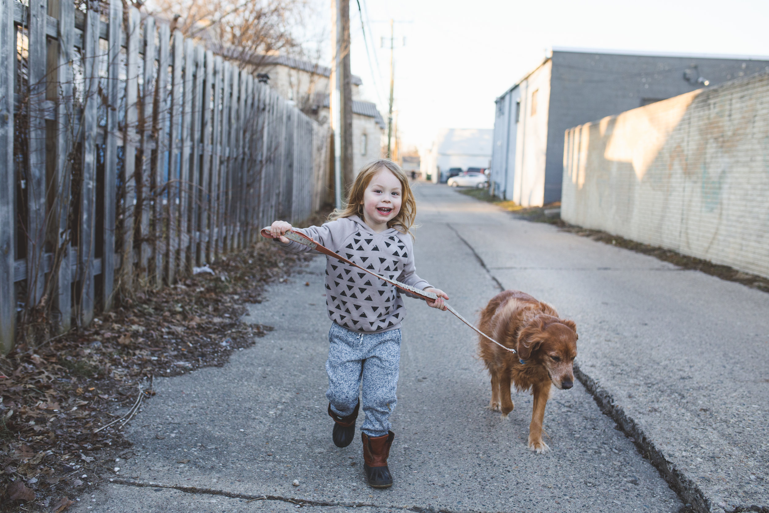 Little boy and dog in alley.