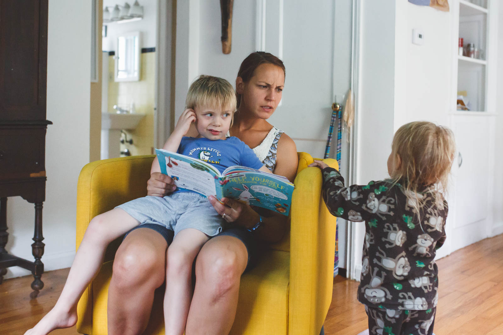 Mom reading to boy on lap.