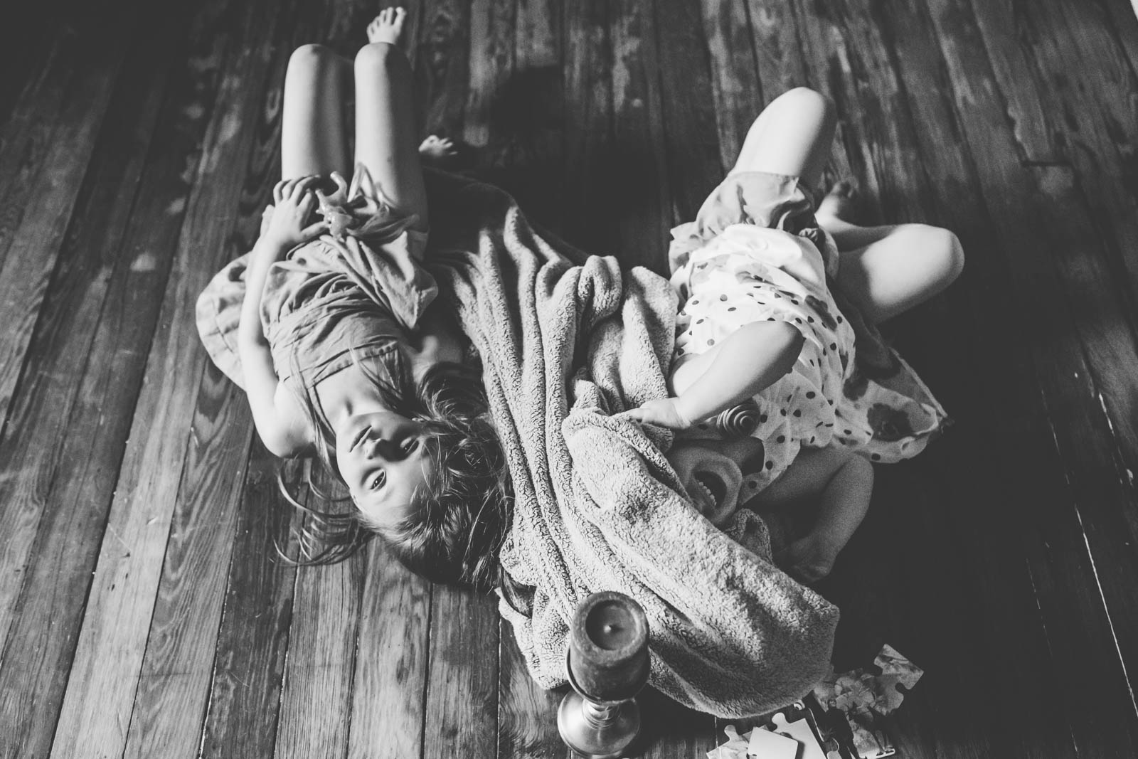 Sisters playing in blanket.