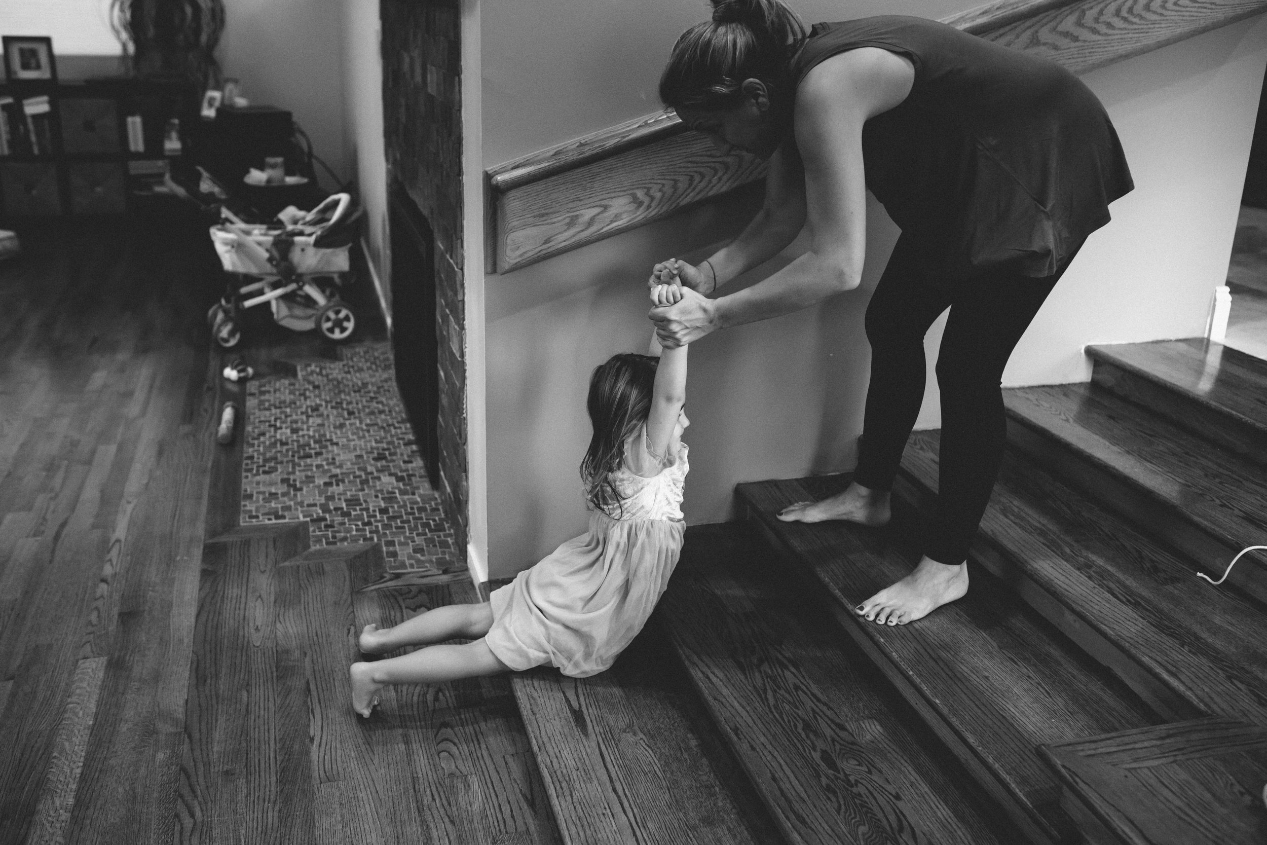 Mom pulling daughter up stairs.