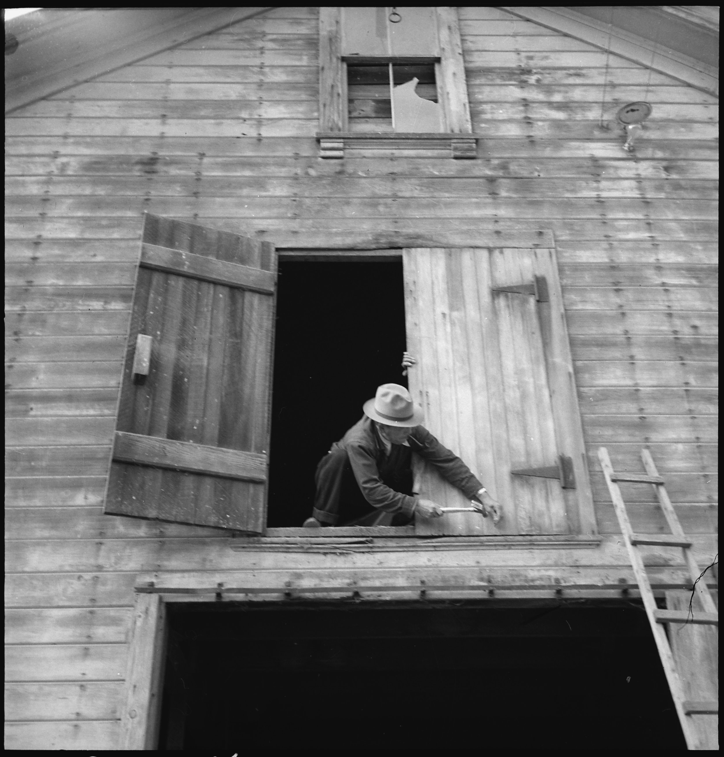  Centerville, California. Nailing the hayloft door on the morning of evacuation. Farmers and other evacuees of Japanese ancestry will be given opportunities to follow their callings at War Relocation Authority centers where they will spend the durati