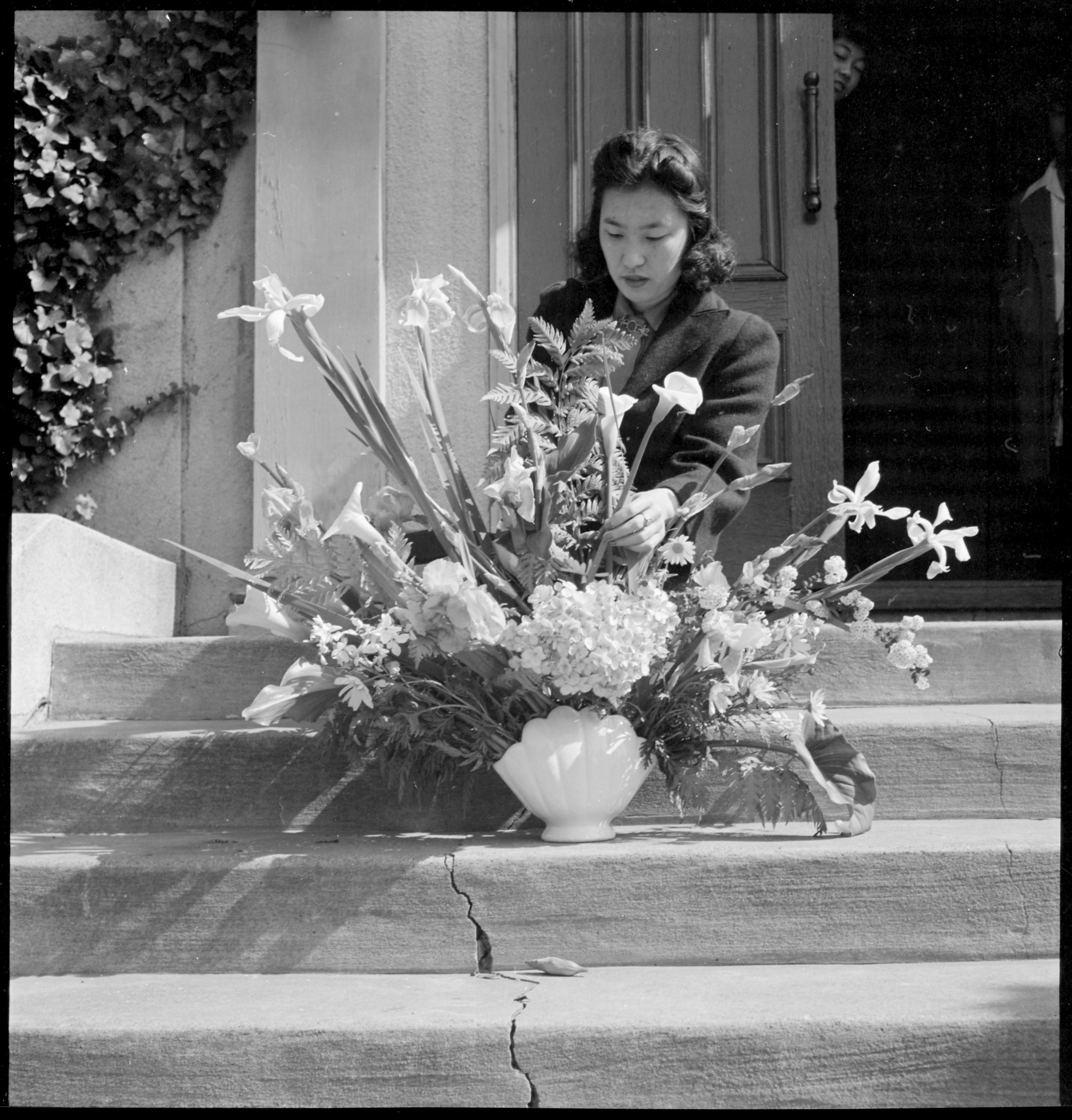  Oakland, California. Arranging flowers for altar on last day of service at Japanese Independent Congregational Church, prior to evacuation. Evacuees of Japanese ancestry will be housed at War Relocation Authority centers for the duration. 
