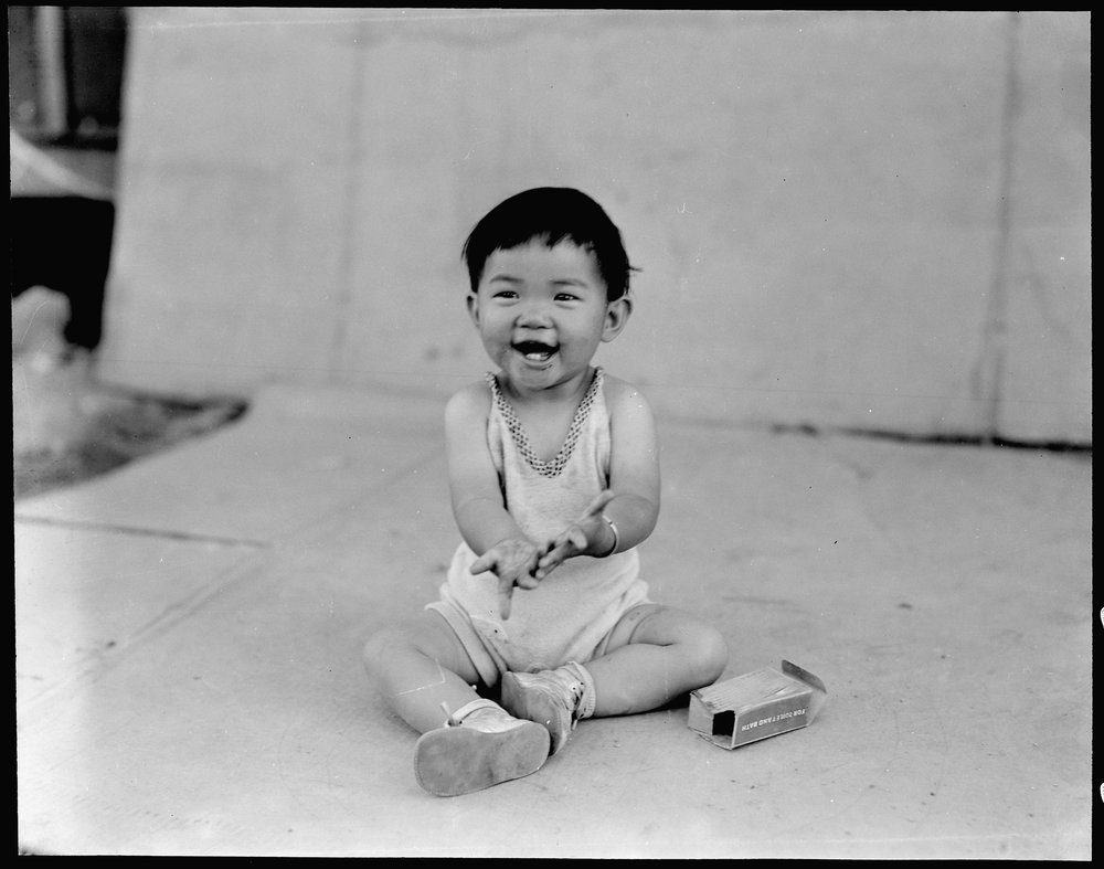  Manzanar Relocation Center, Manzanar, California. Little evacuee of Japanese ancestry in a happy mood at this War Relocation Authority center. 