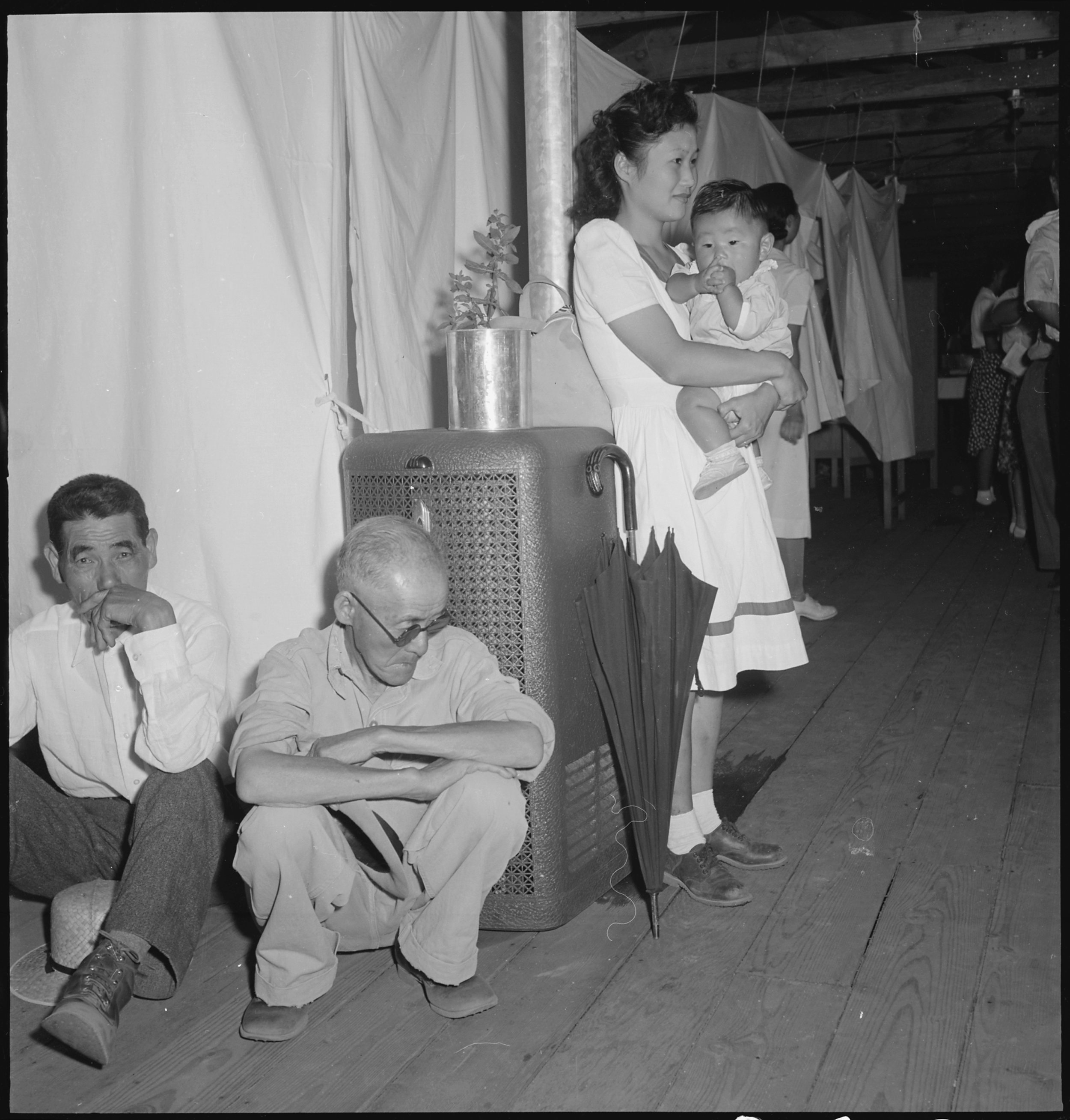  Manzanar Relocation Center, Manzanar, California. A typical interior scene in one of the barrack apartments at this center. Note the cloth partition which lends a small amount of privacy. 