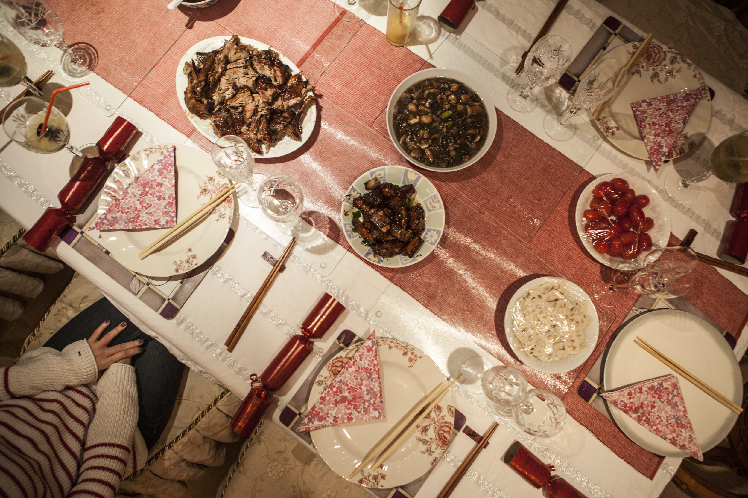  Table set with Christmas crackers alongside traditional Chinese dishes: roast duck, sweet and sour ribs, and lotus root.&nbsp; 