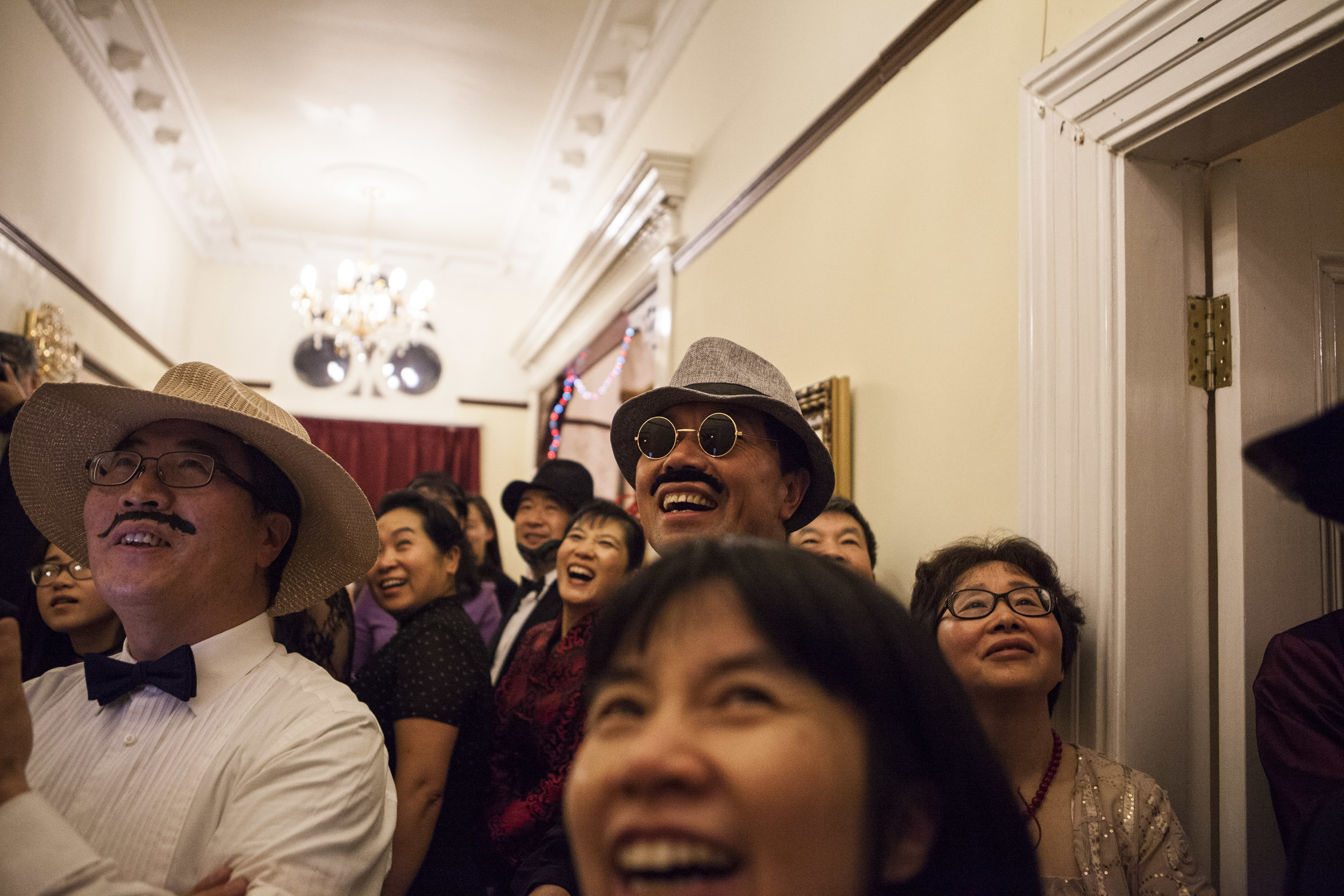  Crowd of Chinese parents watch in fancy dress as their friends perform a procession down the staircase.&nbsp; 