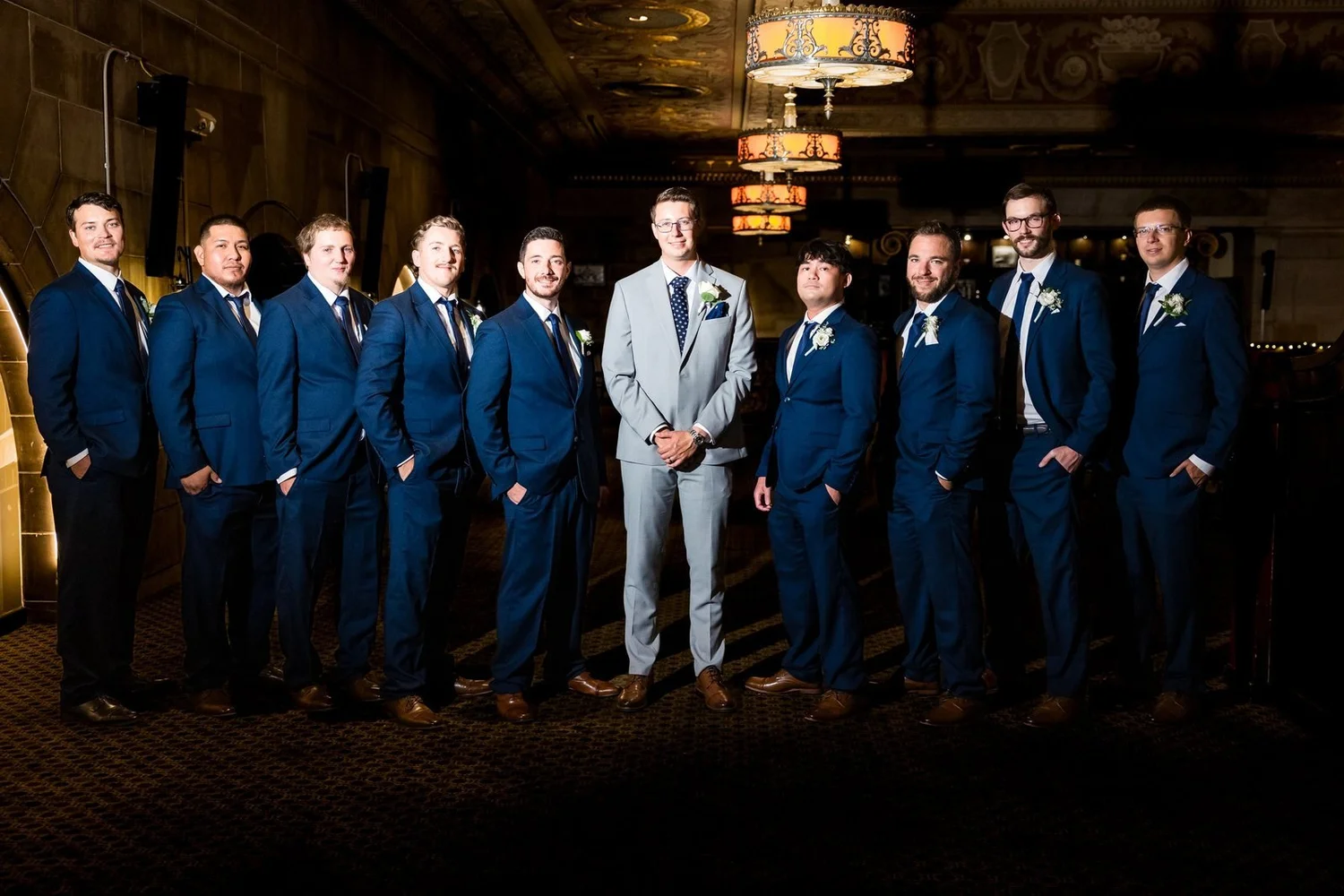 The Society Room of Hartford wedding photographer, Hartford, CT â€” groom and groomsmen in navy suits beneath the bronze lanterns of the former Society for Savings banking hall