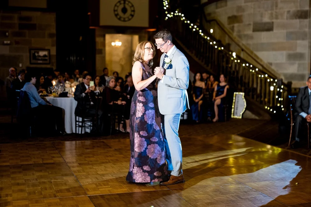 The Society Room of Hartford wedding videographer, Hartford, CT â€” mother-son dance beside the sweeping staircase, string lights, and historic clock