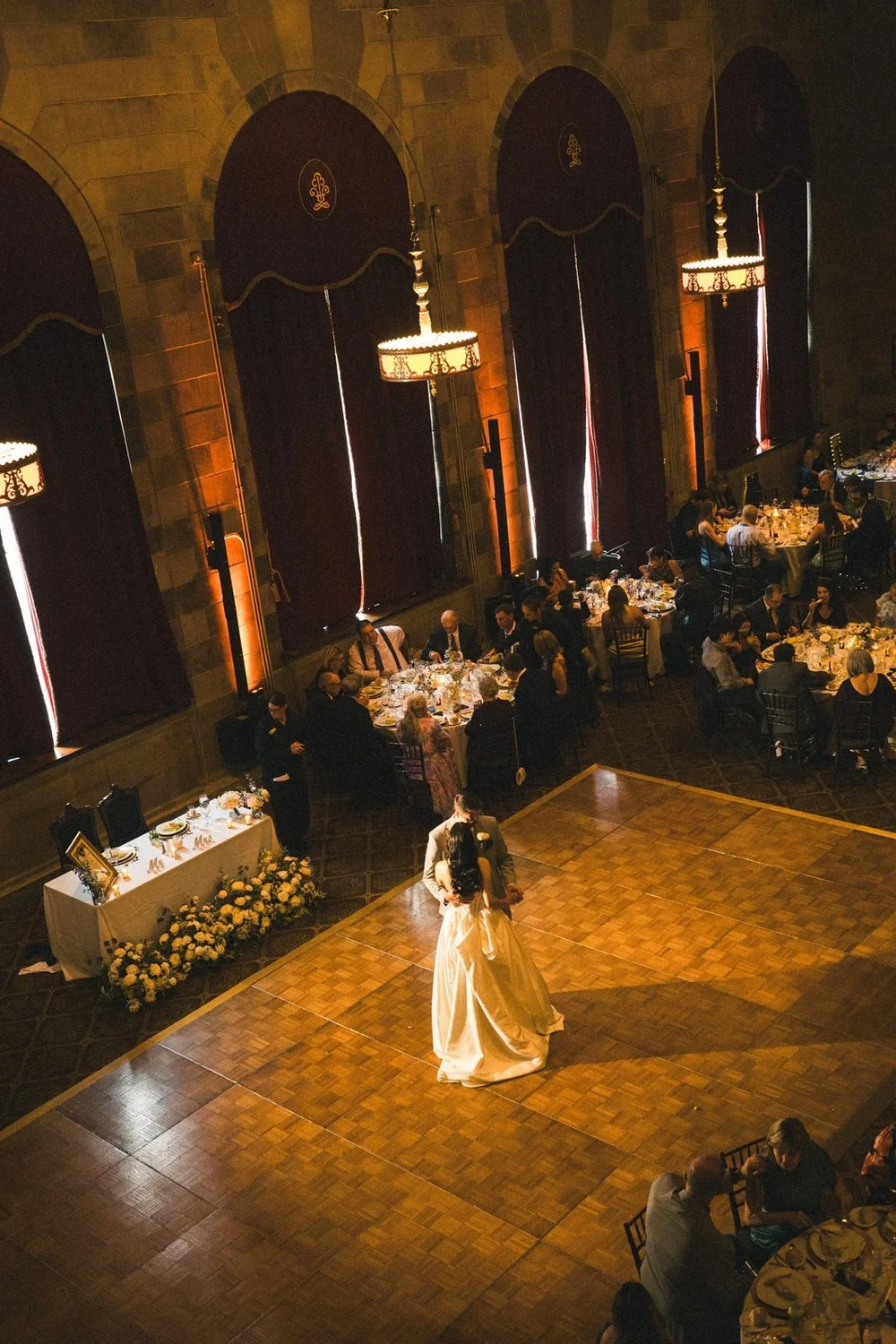 The Society Room of Hartford wedding videographer, Hartford, CT â€” overhead view of the first dance from the 3,000-square-foot balcony with arched windows and red drapes