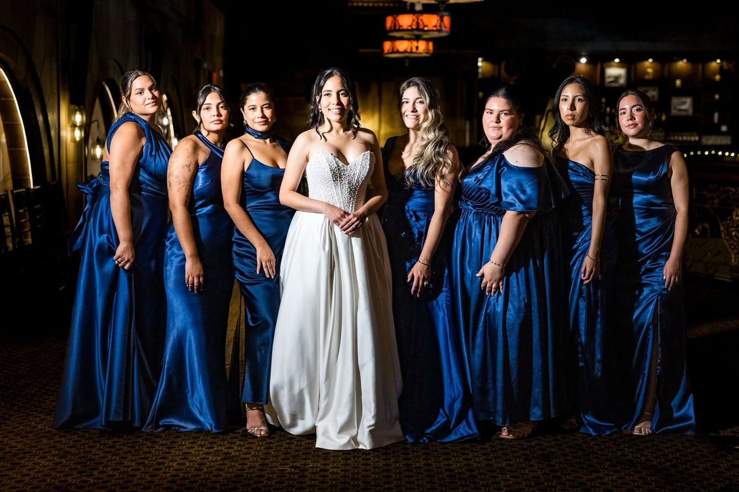 The Society Room of Hartford wedding videographer, Hartford, CT â€” bride and bridesmaids in navy gowns posed inside the brownstone banking hall