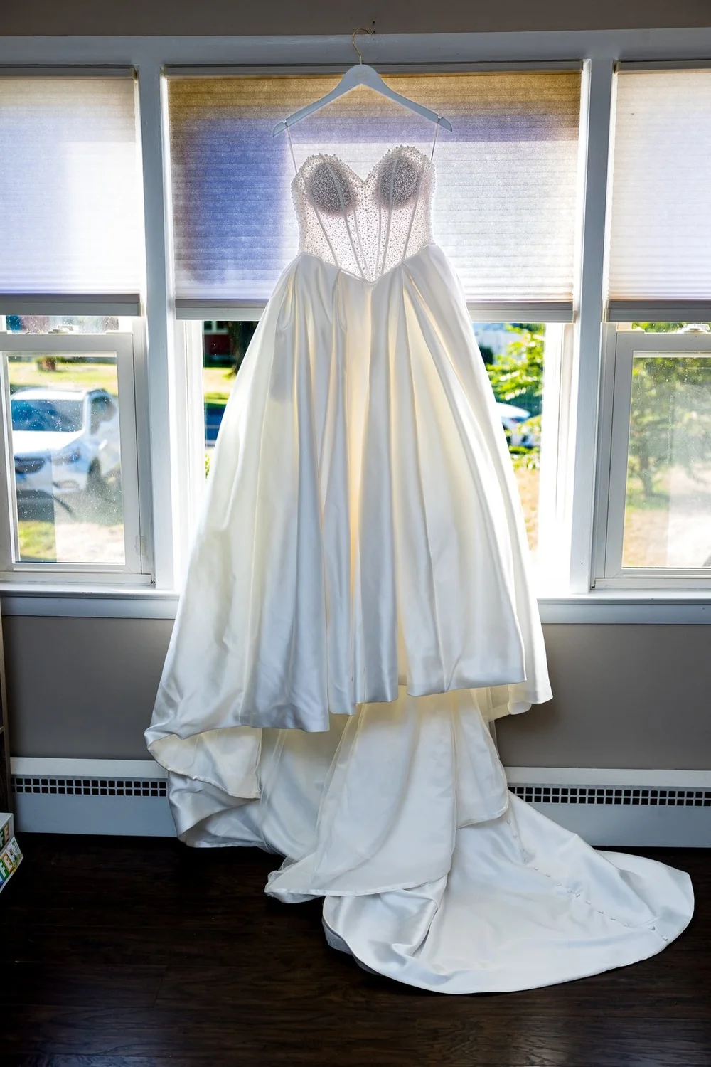 The Society Room of Hartford wedding photographer, Hartford, CT â€” strapless ballgown hanging in the window light on the wedding morning