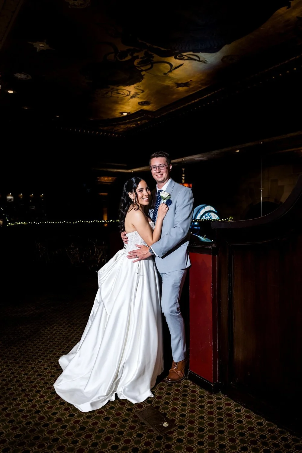 The Society Room of Hartford wedding videographer, Hartford, CT â€” couple embracing in the dim, wood-paneled glow of the historic bank interior