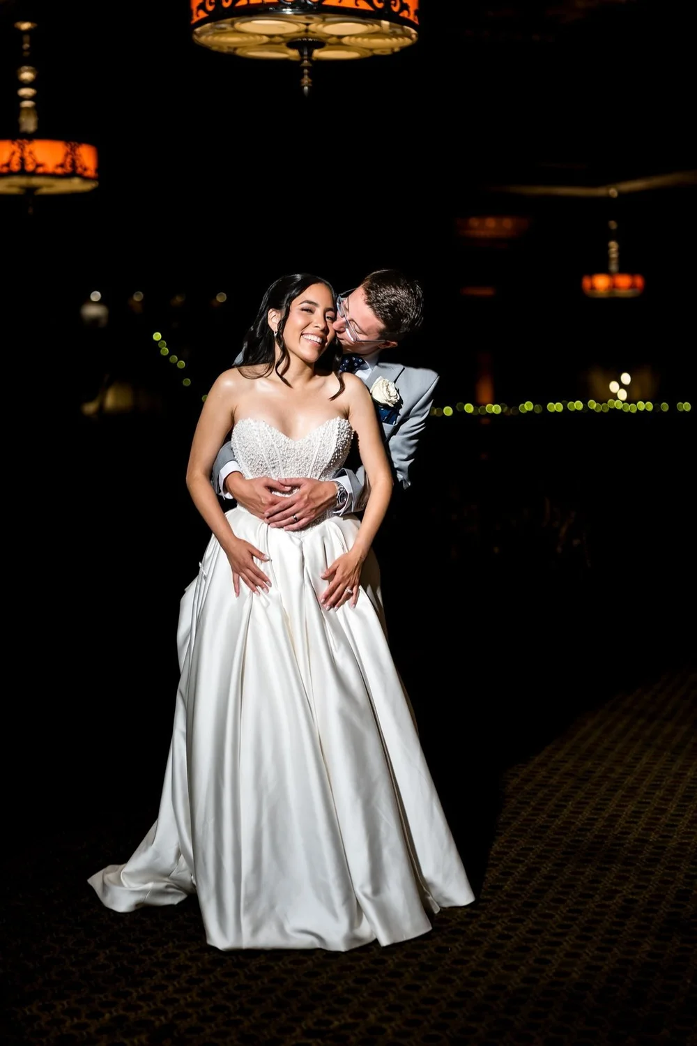 The Society Room of Hartford wedding videographer, Hartford, CT â€” bride and groom framed by warm string lights during evening portraits