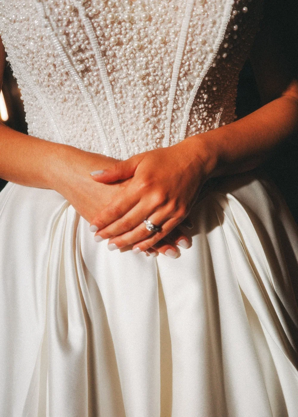 The Society Room of Hartford wedding videographer, Hartford, CT â€” detail of the bride's hands and ring against her beaded bodice
