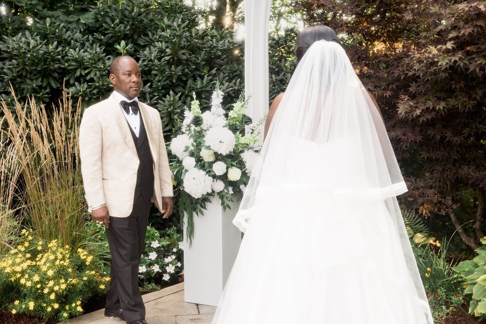 Avenir wedding videographer, Walpole, MA — groom waiting as the bride approaches through the garden in her cathedral veil
