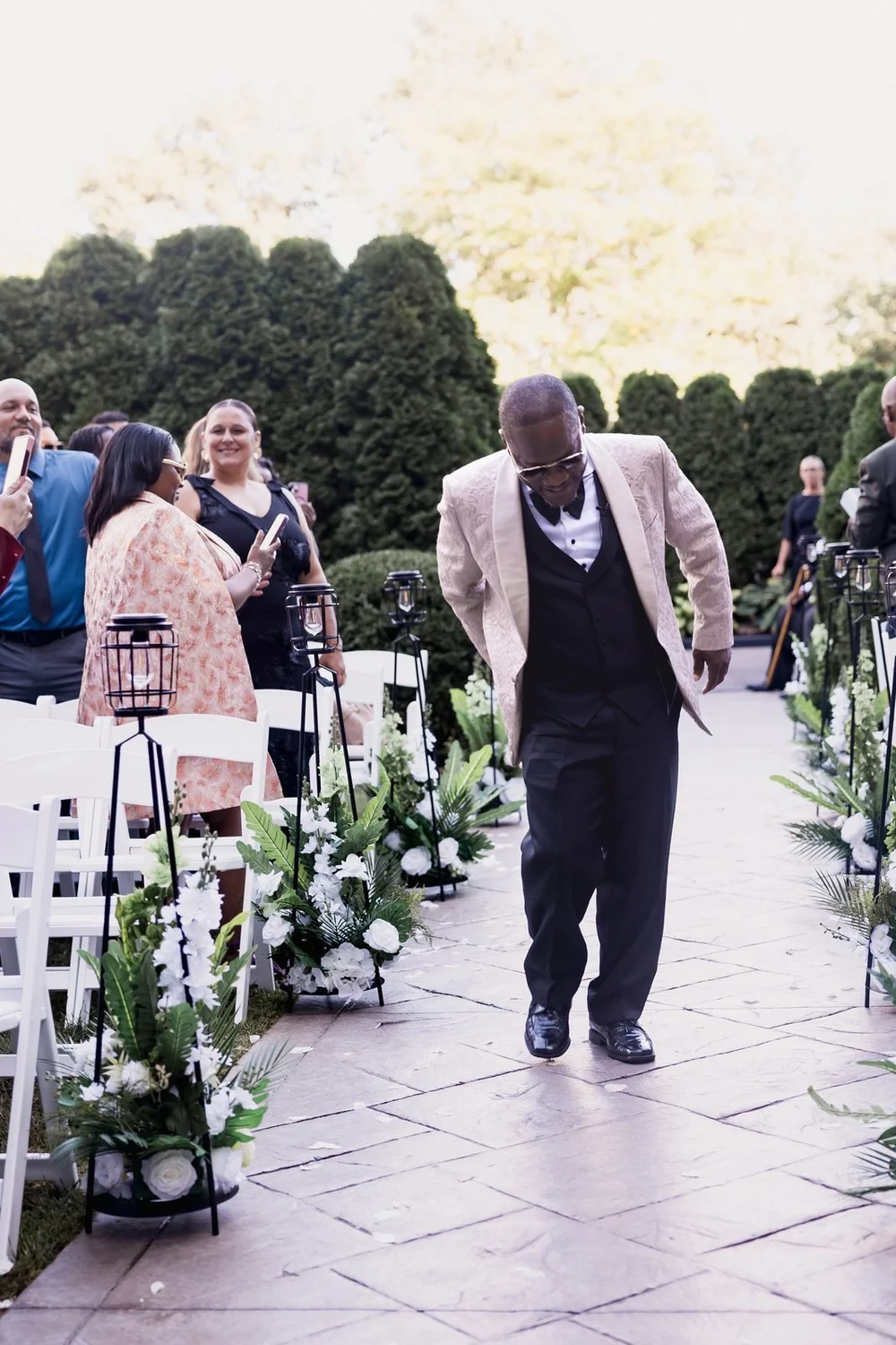 Avenir wedding photographer, Walpole, MA — groomsman walking the stone garden aisle past white chairs