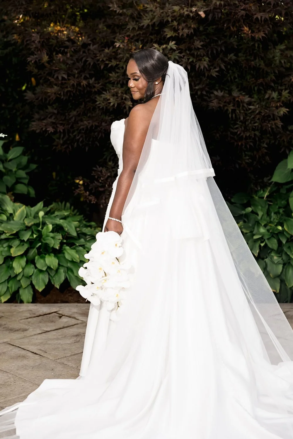 Avenir wedding photographer, Walpole, MA — bridal portrait with a cathedral veil against green hedges