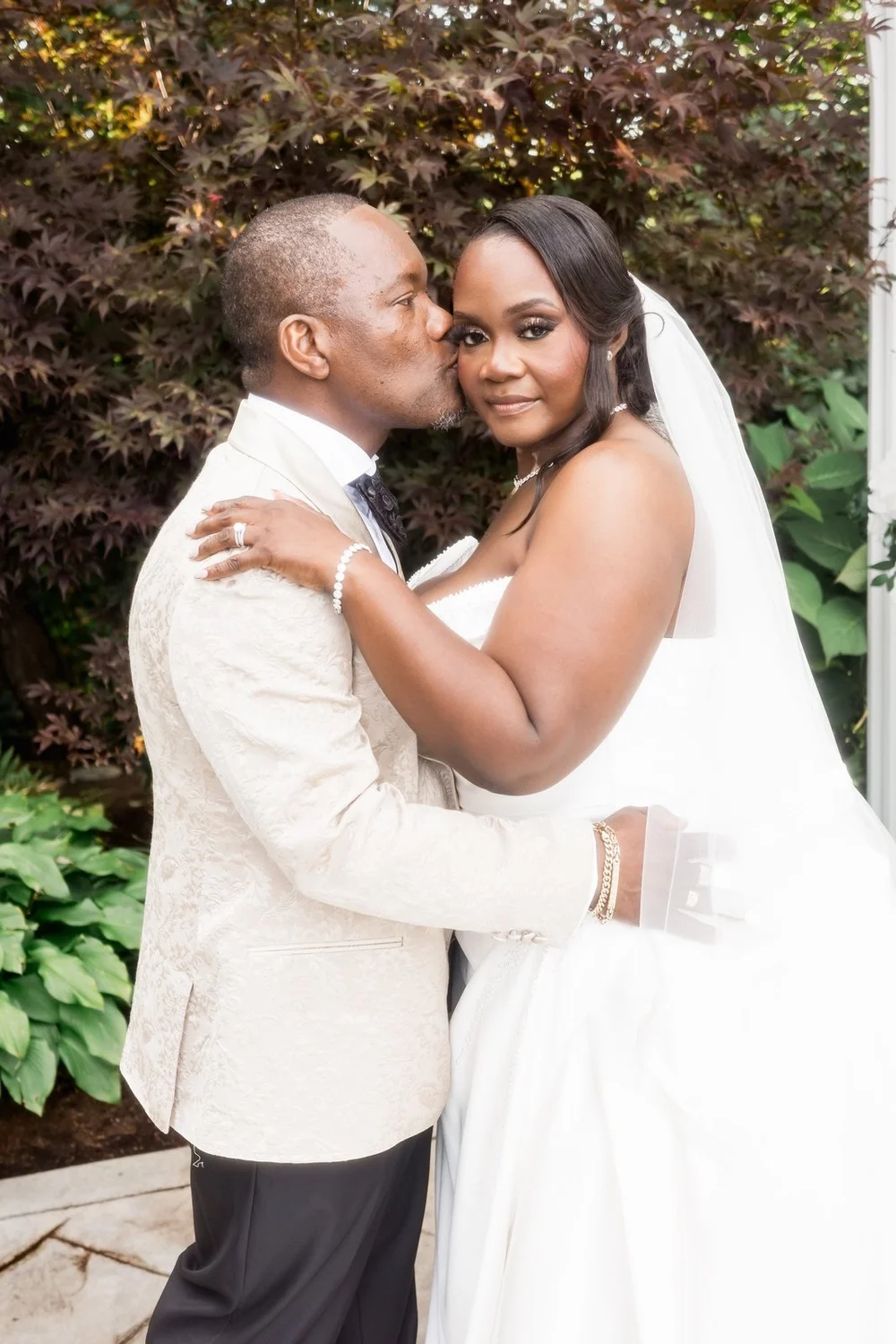 Avenir wedding photographer, Walpole, MA — groom kissing the bride's cheek beside the hedges