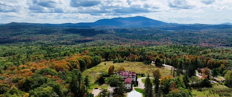 Aldworth Manor wedding photographer and videographer, Harrisville, NH: aerial drone view of the hilltop estate and Mount Monadnock in fall foliage