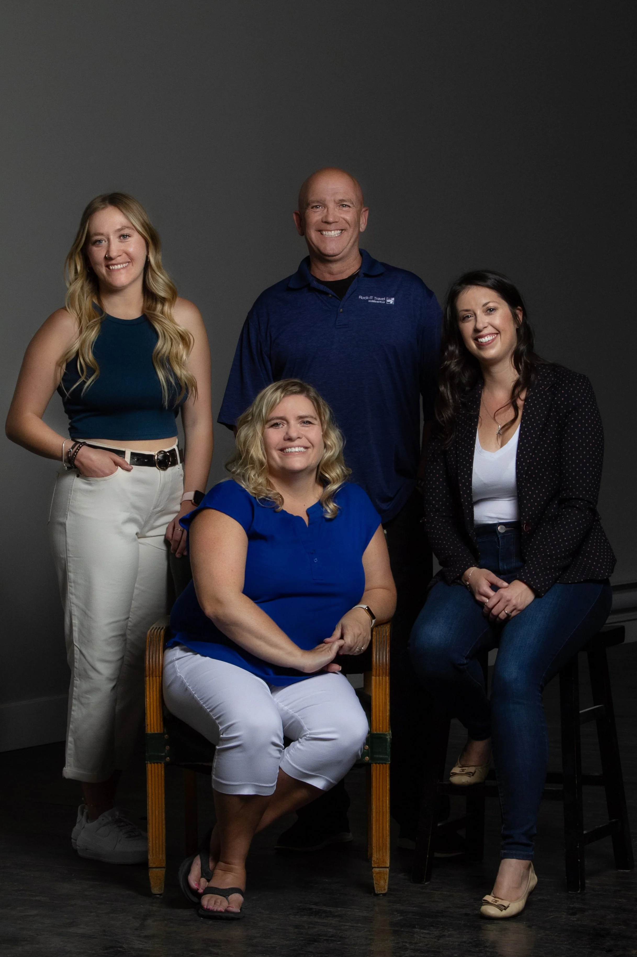 A group photo of the Rock-It Travel Team. From the Left, standing is Breanne King, Kevin Sharp, Ashlee Pearce and CEO Shauna Sharp is in the middle sitting in the chair.
