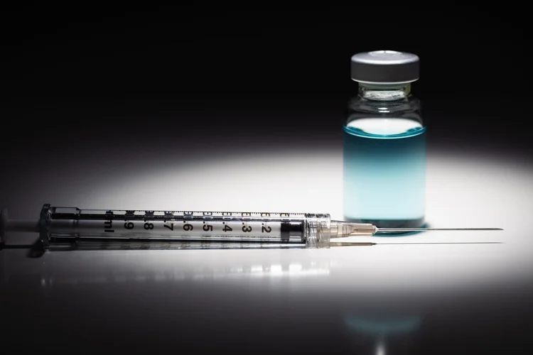 A small glass vial and a syringe