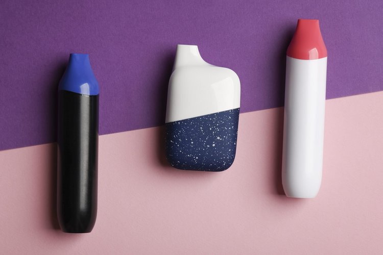 Three disposable nicotine vapes in different shapes and colors
