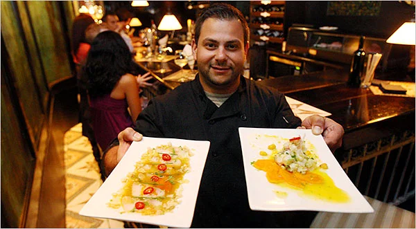 Owner of Desnuda Holds Two Dishes For Photograph.jpg