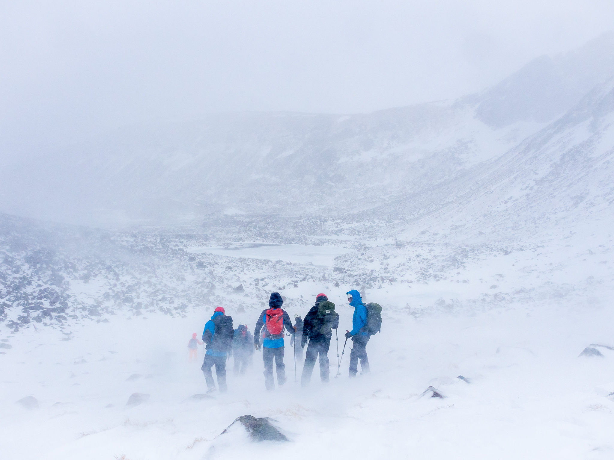  The team descends from cutting snow steps on the slopes of Corie an Sneachda during a blizzard. 