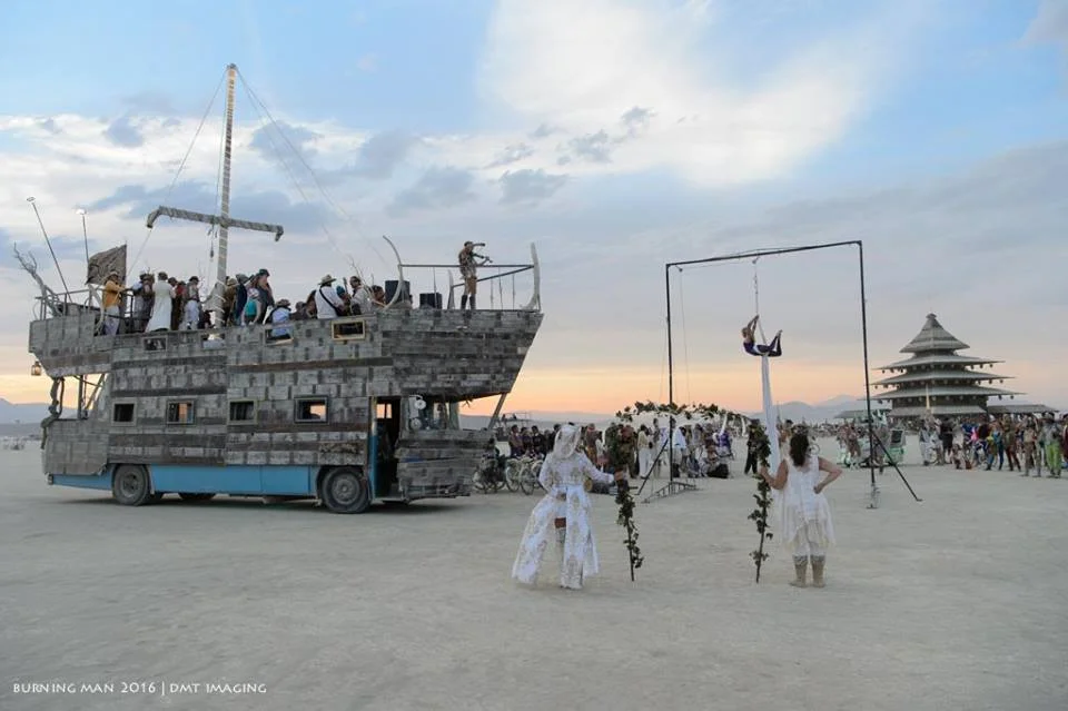 The Anostraca with Violin Girl playing on her bow, I am on the white silks with the Temple in the background at sunset. Photo by Michael Troutman