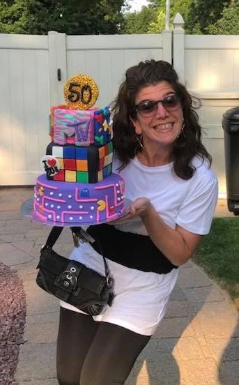 Me delivering a cake while posing for photos as I’m walking into a party. “Can you at least let me put my purse down!”