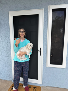 Boss client holding a dog beside her security screen door