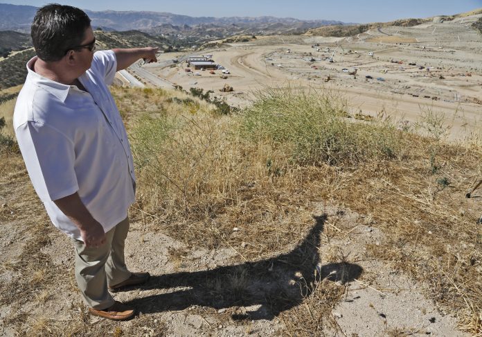 Project manager Randy Wrage points to where buildings and athletic fields will be completed by August 2019 at the site of the future Castaic High School during a media tour on Friday, June 16, 2017. Katharine Lotze/The Signal